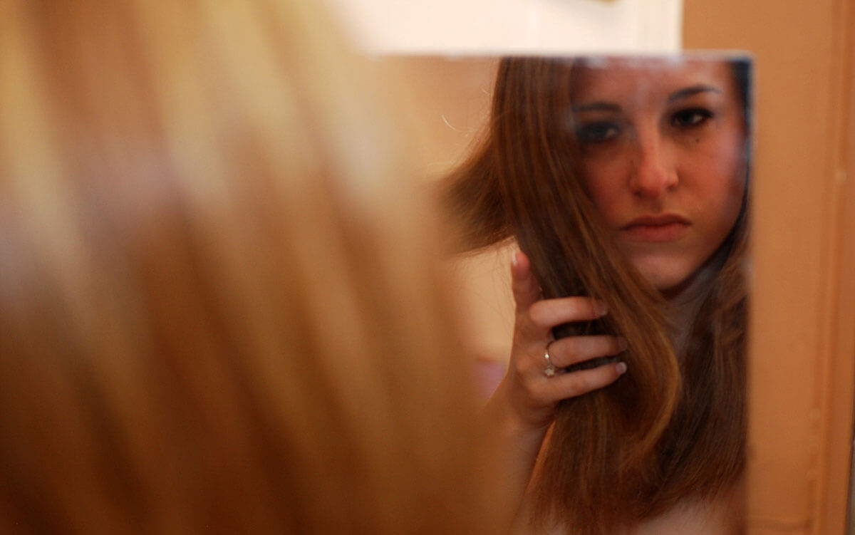 woman looking in mirror
