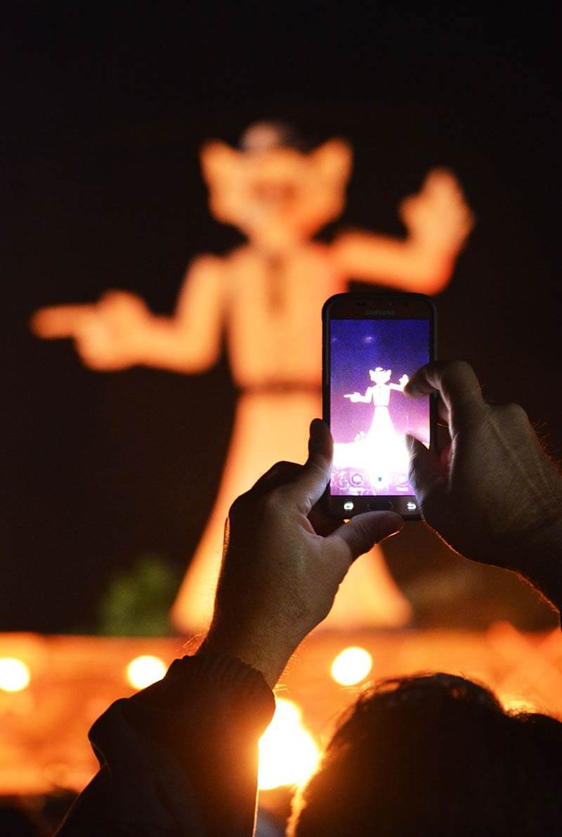 person taking a photo of zozobra