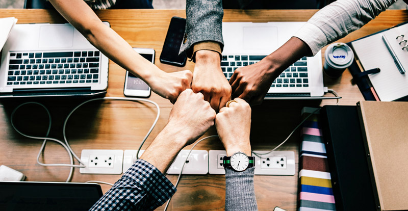 Colleagues bumping fists in a circle