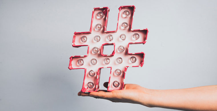 person holding a hashtag shaped prop with lights